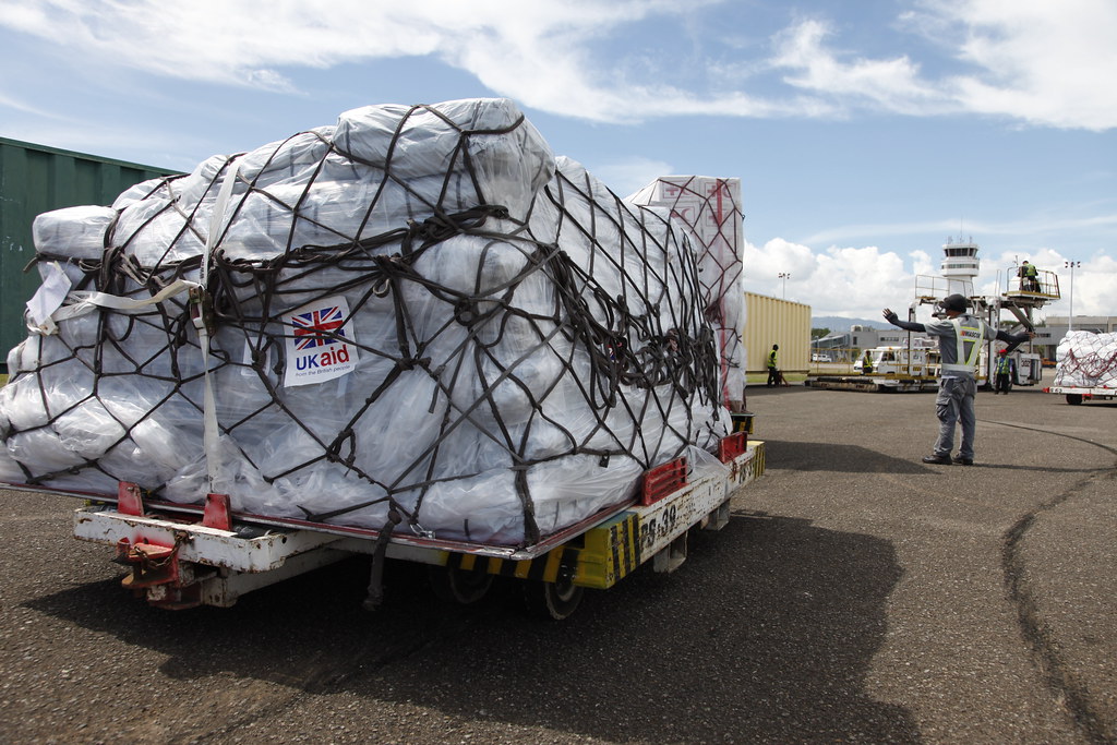 truck carrying parcels labelled with 'UK aid' arrives at an an airport